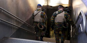 Zwei Soldaten steigen eine Treppe zu einer U-Bahn-Station in Brüssel herunter