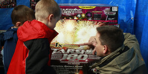 Mann und zwei Kinder betrachten eine Feuerwerksbox
