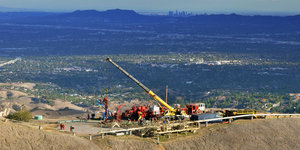 schweres Gerät über dem Gasleck, im Hintergrund die Skyline von L.A.