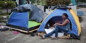 Eine Kubanerin sitzt vor ihrem Zelt in Costa Rica