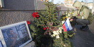Ein Mann kniet am Ort der Ermordung Nemzows