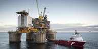 Eine Ölplattform in der Nordsee, davor ein Schiff.