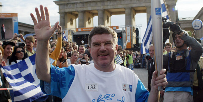 Thomas Bach mit einer Fackel in der Hand