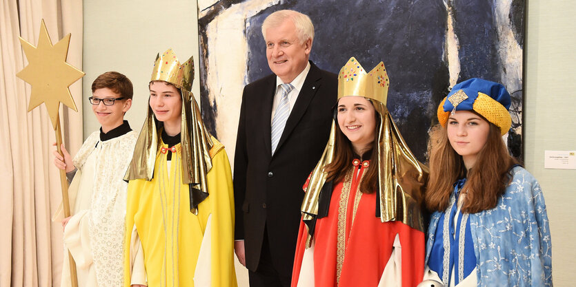 Seehofer, eingerahmt von jungen Sternsingern - aufgestellt für ein Foto.