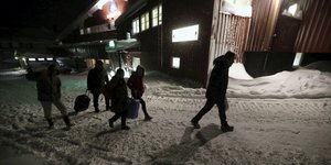 Menschen mit Taschen laufen durch den Schnee