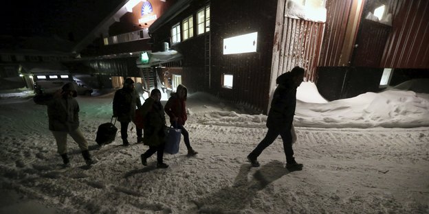 Menschen mit Taschen laufen durch den Schnee