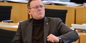 Mann mit Brille mit halb gehobenem Arm, es ist der thüringische Ministerpräsident Bodo Ramelow (Linke)