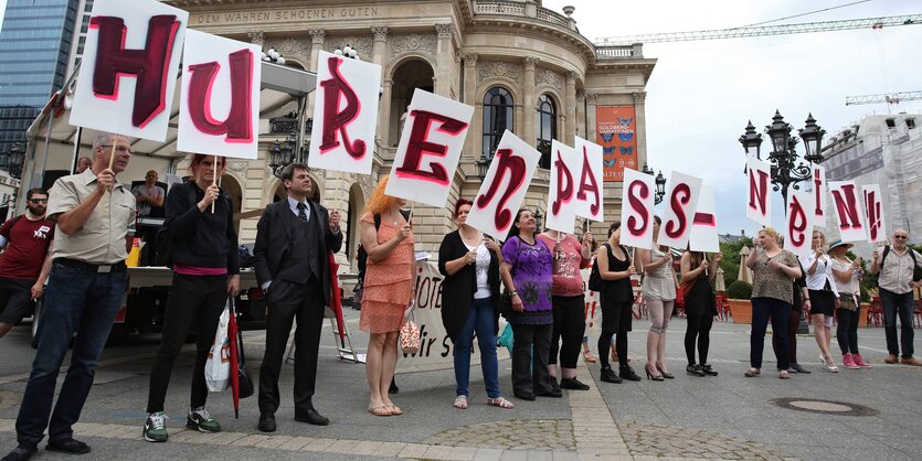 Demonstranten halten Schilder mit der Aufschrift "Hurenpass - Nein" hoch.