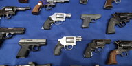 Pistolen verschiedener Fabrikate auf einem blauen Tuch