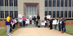 Menschen stehen mit Schildern vor einem Gerichtsgebäude in Texas