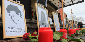 Kerzen stehen vor Bilder von Oury Jalloh