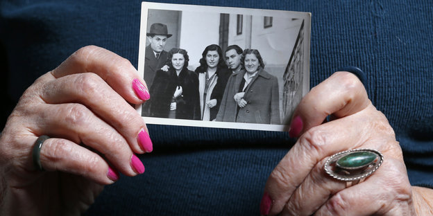 Die Auschwitz-Überlebende Erzsebet Broth hält ein Foto von ihrer Familie in den Händen.