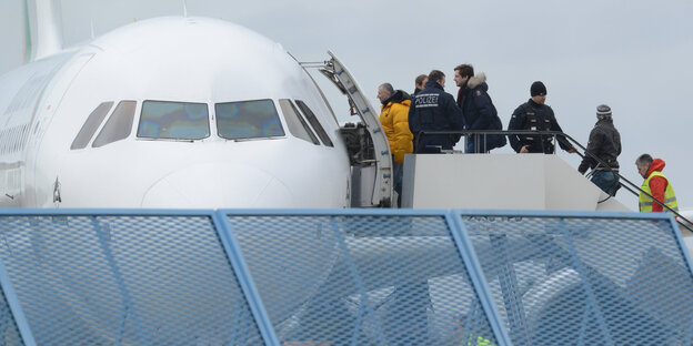 Abgelehnte Asylbewerber besteigen ein Flugzeug bei einer Sammelabschiebung