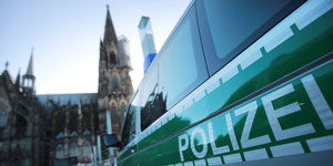 Polizeifahrzeug, im Hintergrund der Kölner Dom