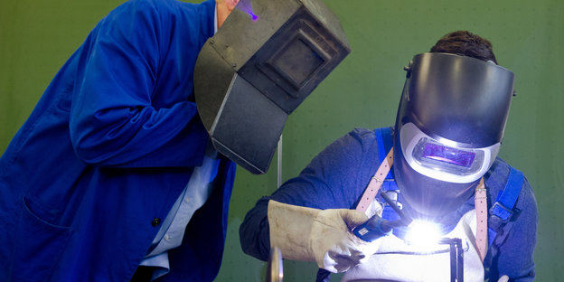 Zwei Arbeiter mit Schutzmasken bei einer Schweißarbeit