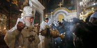 Ein Patriarch schwenkt in einer Kirche das Weihrauchfass