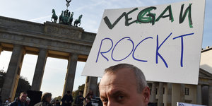 Demonstrant mit Transparent „vegan rockt“ vor dem Brandenburger Tor