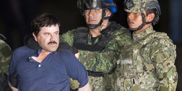 Joaquín „El Chapo“ Guzmán wird von zwei Männern in Uniform abgeführt.