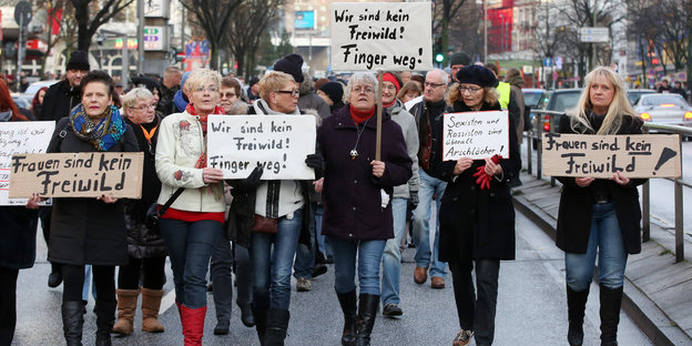 Mit Schildern mit der Aufschrift "Frauen sind kein Freiwild!" demonstrieren Frauen auf der Reeperbahn.