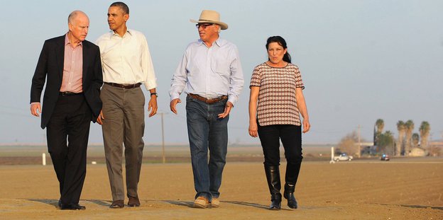 Eine Frau und drei Männer, darunter Barack Obama, auf einem Feld