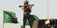 Ein saudischer Soldat steht auf einem Militärfahrzeug, im Hintergrund eine saudische Flagge