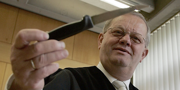 Ein Richter hält ein Messer in der Hand
