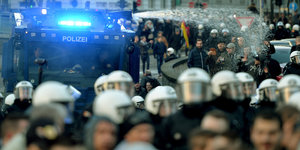 Demonstranten, Bereitschaftspolizisten und ein Wasserwerfer im Einsatz