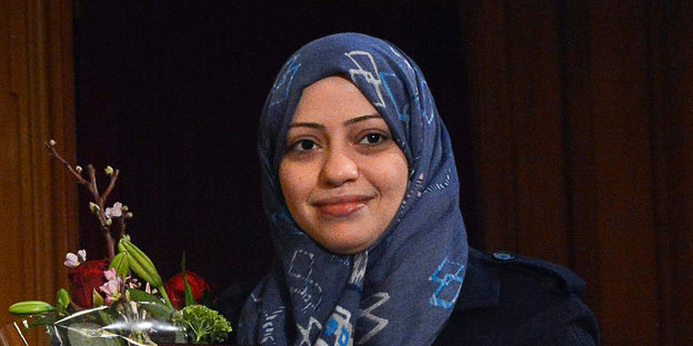 Aktivistin Badawi mit Blumen und Urkunde (nicht im Ausschnitt)