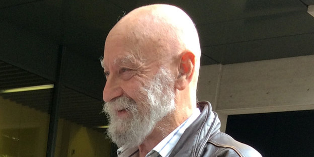 Karl-Heinz Hoffmann, ein alter Mann mit Glatze und Bart, lächelt