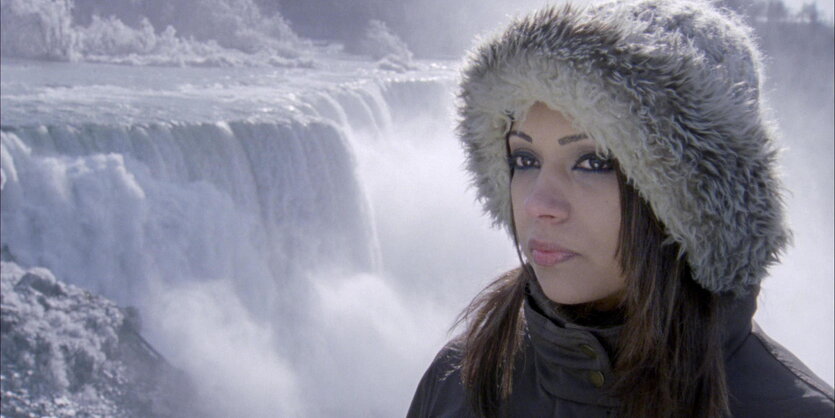 Eine Frau steht vor den Niagara-Fällen