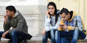 StudentInnen sitzen in Tunis auf einer Treppe