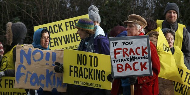 Menschen demonstrieren mit Schildern gegen Fracking