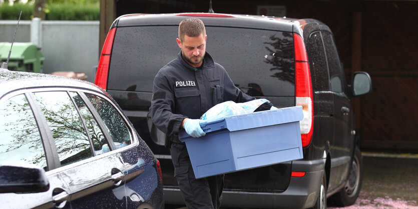 Ein Polizist transportiert Material ab