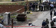 Ein toter Palästinenser liegt auf der Straße. Ein weißes Tuch auf seinem Gesicht. Der Bereich wird von israelischen Sicherheitskräften abgesperrt.