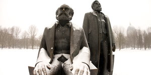 Metallstatuen von Marx (sitzend) und Engels (stehend) im Schnee