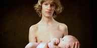 junger nackter Mann mit Baby auf dem Arm