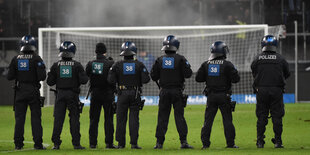 Polizisten vor einem Fußballtor