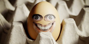 Ein Ei mit einem aufgeklebtem lachenden Gesicht