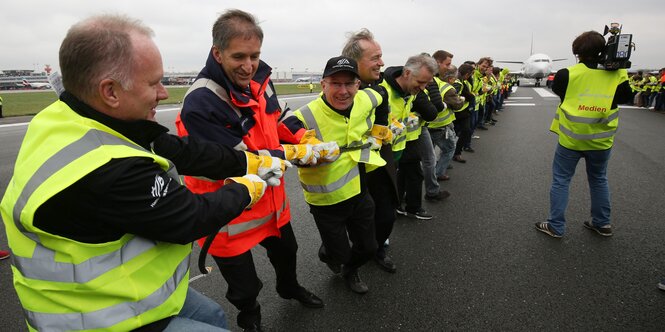 Michael Neumann zieht mit anderen eine Boeing an einem Seil