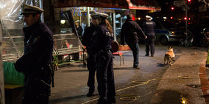 Polizisten stehen bei Nacht auf einer Straße