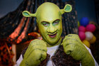 Markus Söder im grünen Shrek-Kostüm mit erhobenen Fäusten