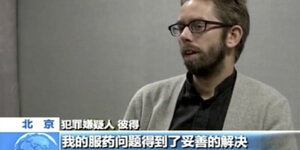 Sendungsausschnitts eines chinesischen TV-Senders. Im Bild ist ein Mann mit Brille zu sehen.