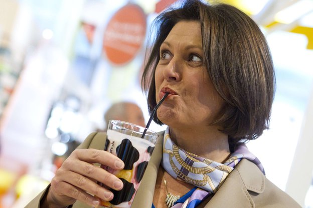 Ilse Aigner trinkt mit einem Strohhalm Milch aus einem Glas mit Kuhflecken