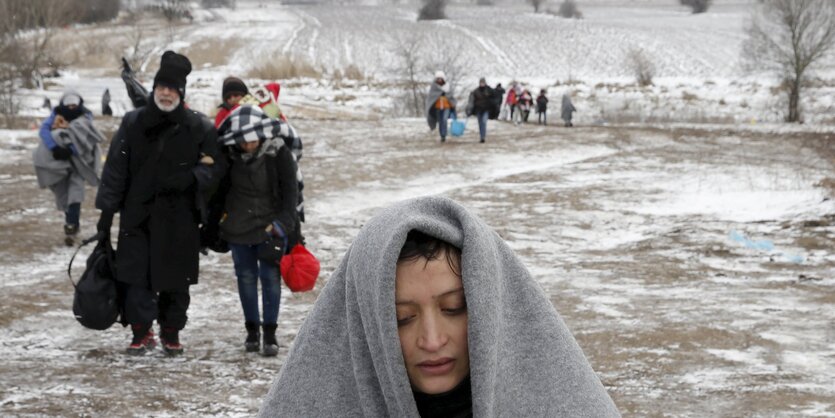 Verstreut gehende Menschen in einer verschneiten Landschaft