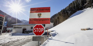 Grenzposten mit Stopp-Schild in verschneiter Landschaft