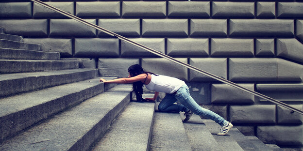 Eine Frau kämpft sich eine Treppe hinauf