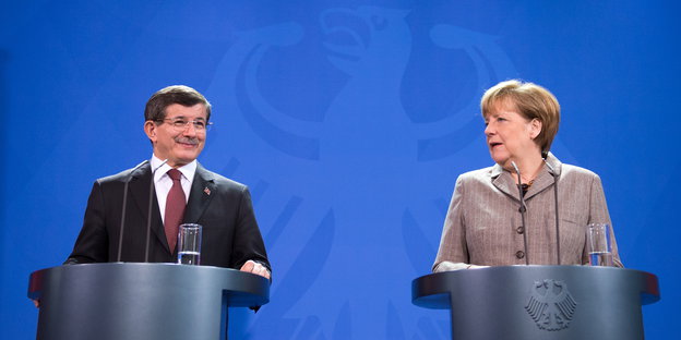 Merkel und Davutoglu vor blauem Hintergrund mit Bundesadler