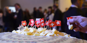 Ein Teller mit Käsestückchen, auf denen Schweizer Fähnchen stecken