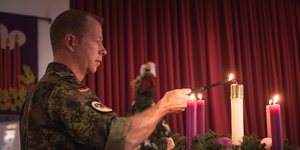 ein Soldat zündet Kerzen an