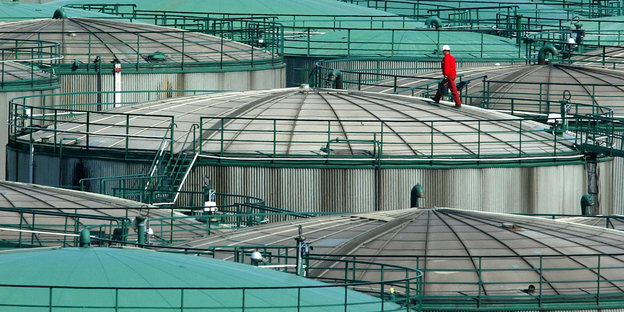 Ein Arbeiter läuft auf dem Dach eines Öltanks auf dem Festland